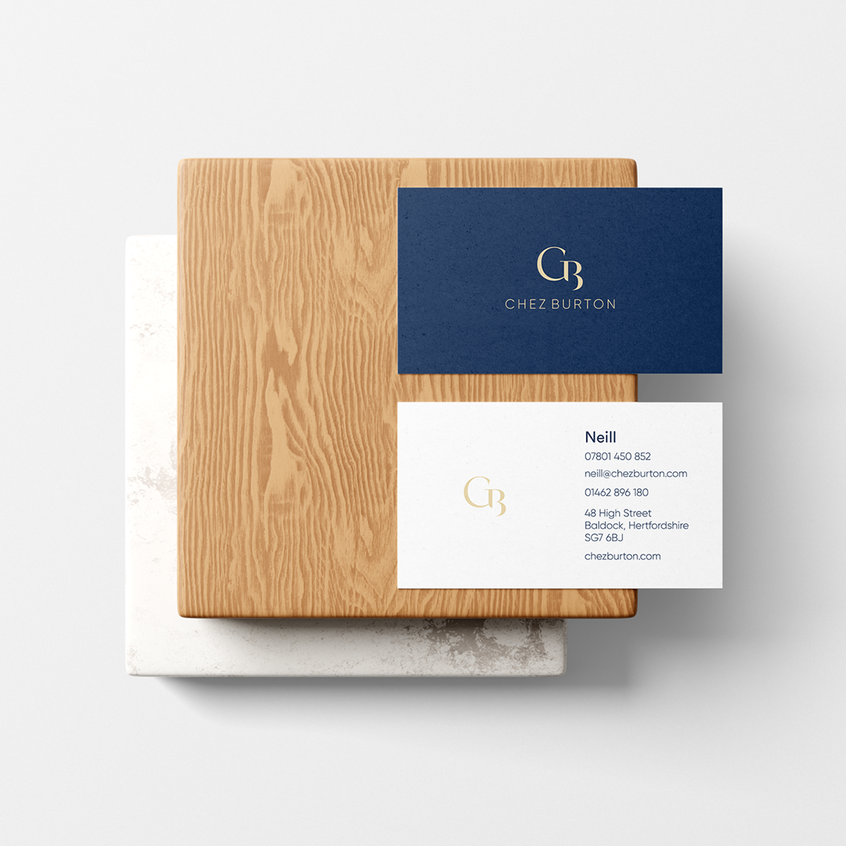 Business card design for Chez Burton set over a wooden chopping board.