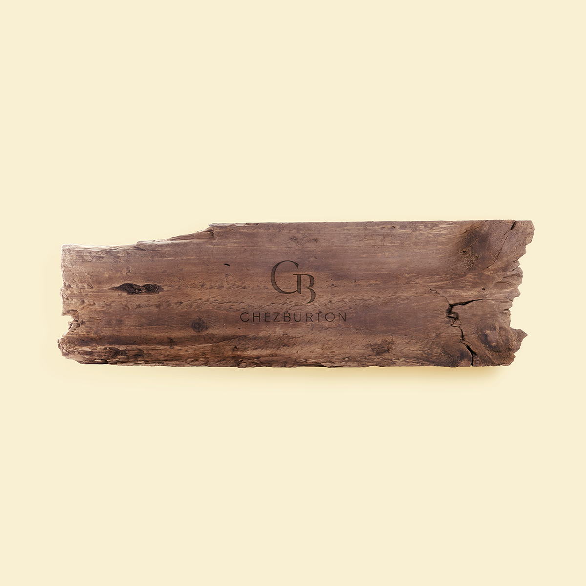 A natural wooden serving board featuring the Chez Burton logo.