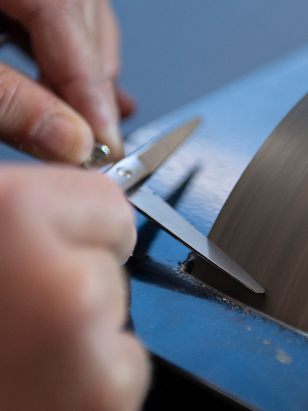 Surgical scissors being sharpened.
