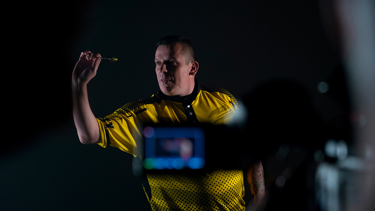 Professional darts player Dave Chisnall throwing a Harrows dart.