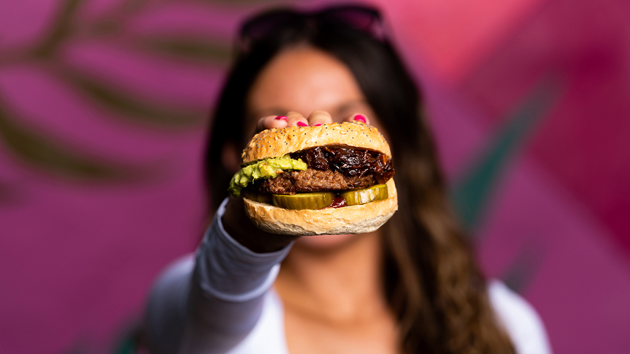 Young woman holding a vegan burger.