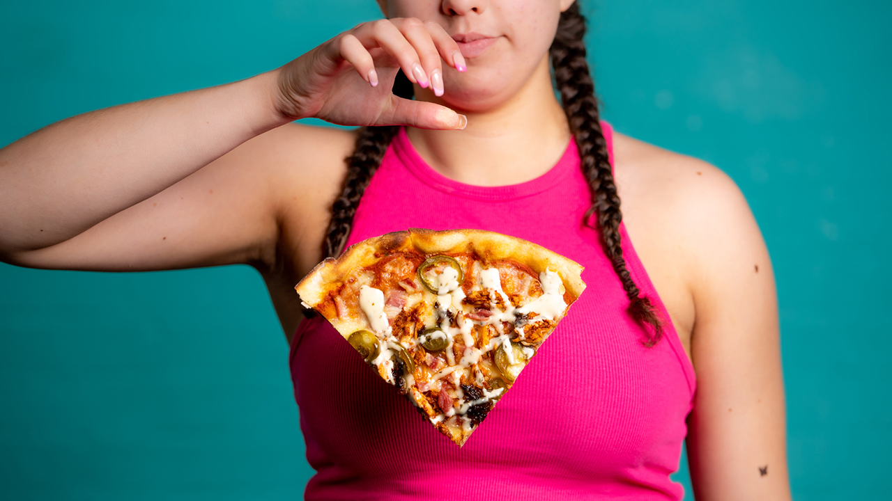 Young woman dropping a slice of pizza.