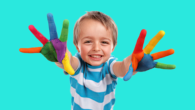 A happy young boy with painted hands.